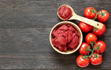 Traditional turkish tomato paste in bowl or spoon with fresh tomatoes on wooden table, homemade healthy food