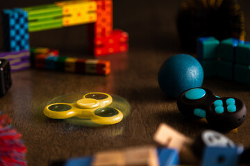 Spinning yellow fidget spinner surrounded by other fidget toys for children. 