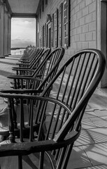 Perspective photo of a line of vintage rocking chairs at George Washington Mount Vernon historical site in Virginia