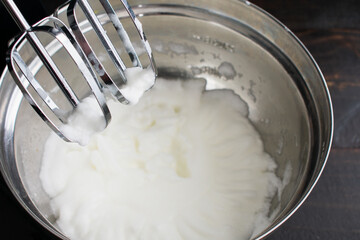 Fototapeta na wymiar Beating Egg Whites to Make Meringue: Egg whites that have been beaten in a stand mixer until they are fluffy