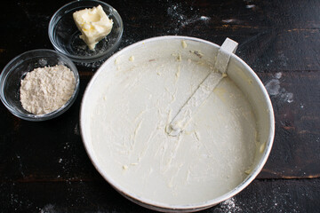 Flouring a Cake Pan: A round cake pan coated in butter and flour
