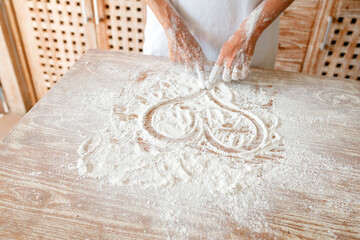 A woman's hand draws a heart on flour, a romantic mood, cooking at home with love