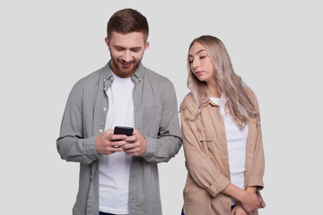 Man Chatting on Phone. Couple Using Phones Standing Isolated. Couple Shopping Online. Girl Watching in Man Phone. Secret in Phone.