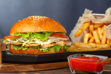Fresh tasty chicken burger and french free on wood table.