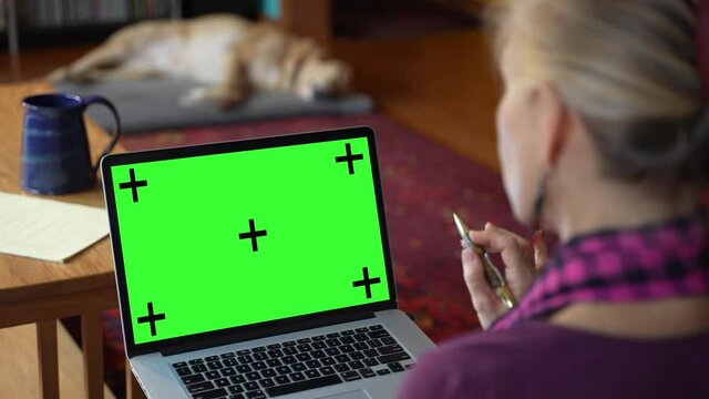 Woman on couch at home using tablet with chroma key green screen, talking to business colleague - internet, communications concept close up 4k template