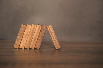 Close-up one wooden block prevent other the wood block from falling domino concepts of financial...