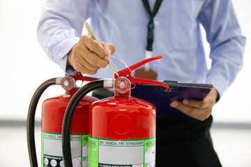 Fire engineering checking pressure gauge level of fire extinguishers tank in the building concepts...