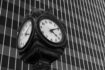 Business image of a clock with a building in the background.