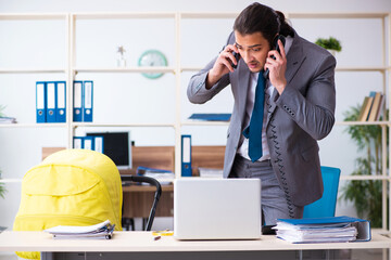 Young male employee looking after newborn at workplace