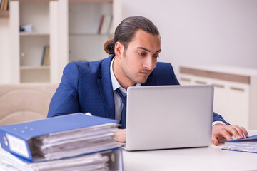 Young male employee working from home in pandemic concept