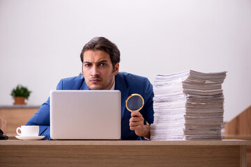 Young male employee unhappy with excessive work in the office