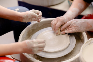 Female hands crafting a pottery cup on a potter's wheel. Handmade and crafting concept. Top horizontal view copyspace.