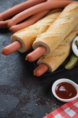 Close-up of french hot dogs or sausages in baguette, vertical shot on a brown stone background, selective focus