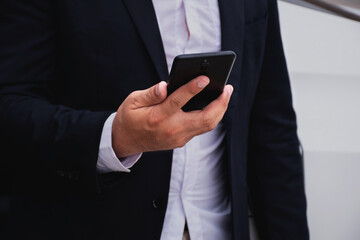 Closeup hand of Businessman wearing suits holding mobile phones, business concept