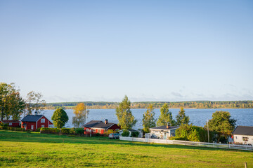 Traditional red scandinavian timber houses near Kr&ouml;n (Kron) lake in autumn. Landscape of Seden
