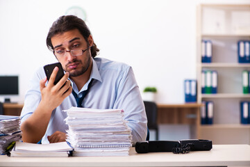 Young male employee unhappy with excessive work in the office