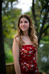 Fototapeta premium Portrait of a young woman, she is wearing a red dress and is smiling