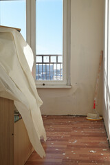 Vertical photo of wall renovation in rooms with paint roller