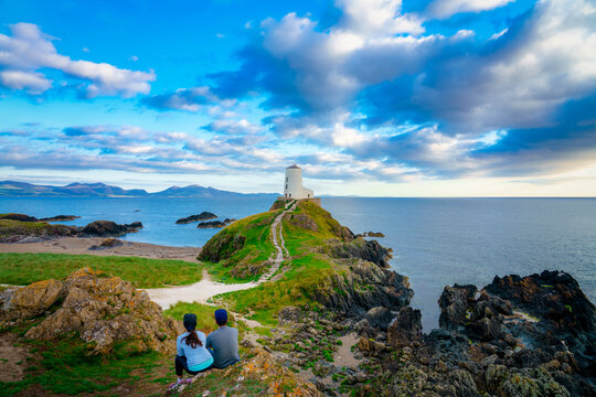 Lighthouse on Llanddwyn Island and Snowdonia mountains in background. North Wales. UK - Powered by Adobe