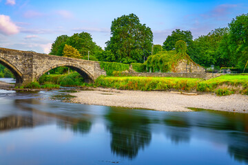Fototapeta na wymiar Stone bridge across the river Conwy, and old cottage covered with vine leaves, Llanrwst, Caernarfon, North Wales