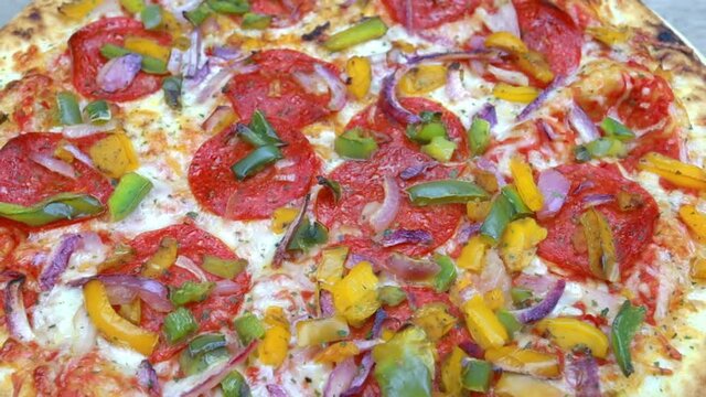 pizza au chorizo, poivrons et oignons rouges sur une table