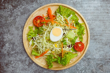 Top view fresh vegetables salad on wooden dish..