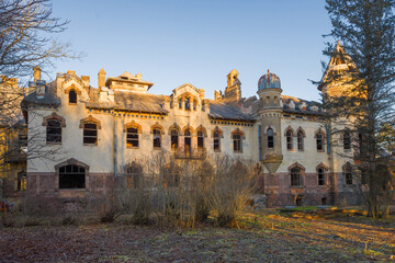 Fototapeta premium View of the abandoned main house of the old Eliseev estate (1912) in the village of Belogorka in early. Leningrad region, Russia