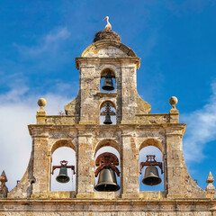 Church steeple with stork and its nest on top of ancient stone architecture.
