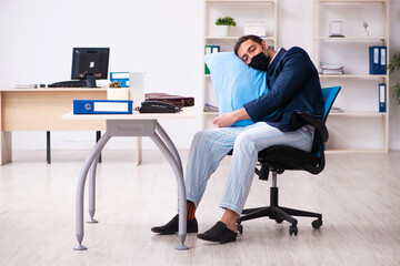 Young male employee during pandemic at workplace