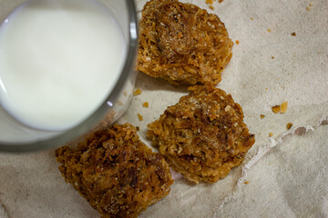 View of crunchy coconut cookies along with hot milk in a glass.