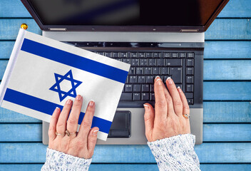 woman hands and flag of Israel on computer, laptop keyboard 