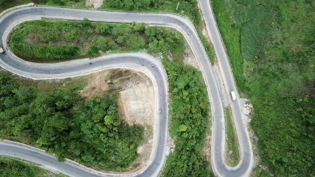 Drone shot of hairpins and winding road in the countryside surrounded by forest and jungle at Ma Pi Leng Pass, Vietnam, Southeast Asia.