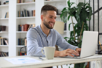 Happy young business man is analizing financial documents from home during self isolation.