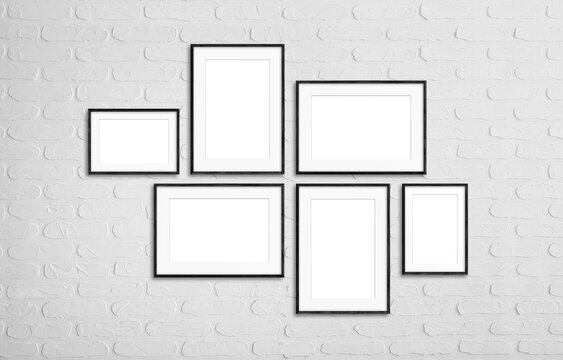 Black photo frames set isolated on white bricks wall, six frameworks mock up