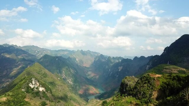 Drone shot of Ma Pi Leng Pass in Ha Giang Province, Vietnam. Tall mountains and the Nho Que river creating an incredible mountain scenery during a sunny day in Southeast Asia.