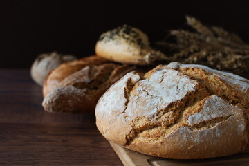 Loaf of sourdough bread with crispy crust on wooden background.