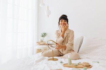 Smiling woman doing skin care at home - obrazy, fototapety, plakaty