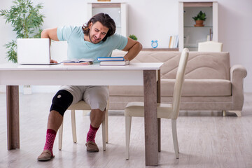 Young leg injured student studying at home