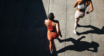 Women running together - Powered by Adobe