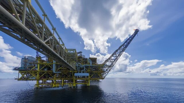 4K time lapse of yellow centre processing platform of oil and gas in the middle of South China sea with blue sky and thick clouds movement.