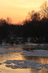 Sunset on the river with frozen water in a winter time