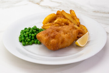 Fish and Chips with Peas and Lemon on a White Plate, a Typical Traditional Dish of British Cuisine with Deep Fried Cod
