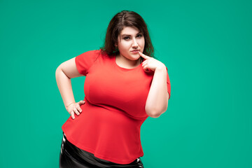 Plus size fashion model in red blouse, fat woman on green background, body positive concept