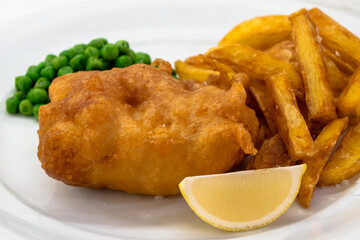 Fish and Chips with Peas and Lemon on a White Plate Close Up, a Traditional Dish of British or English Cuisine