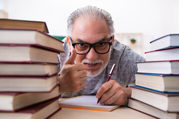 Old male student preparing for exams in the classroom