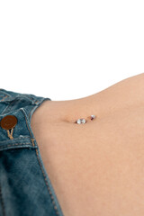Belly button or navel piercing, of young woman wearing jeans isolated on white.