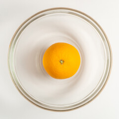 An orange fruit in a bowl. Flat lay view. Square size of photo.