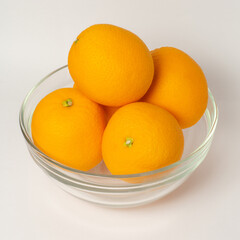 Orange fruit in a bowl on white background. Square size of photo.