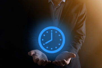 Businessman hand holds the icon of hours clock with arrow. Rapid execution of the work.Business time management and business time is money concepts