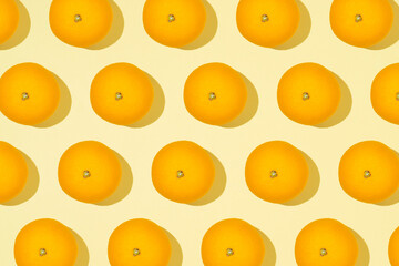 Trendy creative pattern of an orange fruit. Summer creative concept. Flat lay view on a light yellow background.